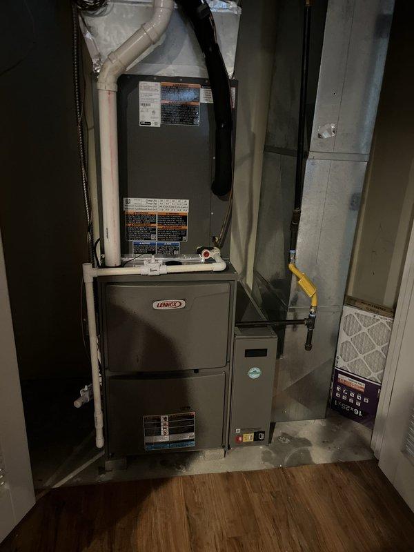 Completed full HVAC system installation including new Lennox furnace and air conditioning condenser unit. Installed furnace in basement utility area with proper metal ductwork connections, PVC condensate drain lines, and venting. Mounted outdoor Lennox AC condenser on concrete pad against exterior brick wall with proper electrical disconnect and conduit installation. Positioned unit in landscaped area with decorative rock surround for optimal airflow and drainage. Connected all electrical controls, refrigerant lines, and communication wiring between indoor and outdoor components. Verified all manufacturer specifications, tested system operation, and confirmed proper heating and cooling functionality throughout the residence.
