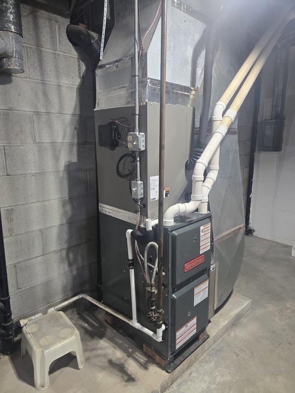 Completed installation of 3.5-ton, 13 SEER air conditioning system with matching evaporator coil in residential basement mechanical room. The new AC system was integrated with the existing Goodman furnace unit, with the evaporator coil installed in the supply plenum above the furnace. All refrigerant lines were properly sized and insulated, condensate drainage was routed through white PVC piping with appropriate trap installation, and electrical disconnect was verified for safe operation. System was pressure tested for leaks, evacuated to manufacturer specifications, charged with proper refrigerant amount per unit nameplate, and tested for correct operation including temperature split verification across the coil.