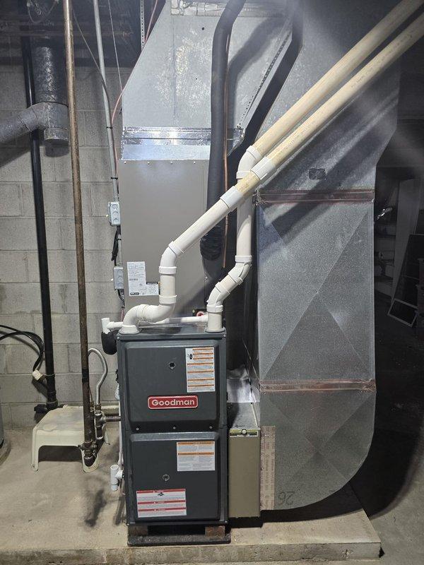 Completed installation of 3.5-ton, 13 SEER air conditioning system with matching evaporator coil in residential basement mechanical room. The new AC system was integrated with the existing Goodman furnace unit, with the evaporator coil installed in the supply plenum above the furnace. All refrigerant lines were properly sized and insulated, condensate drainage was routed through white PVC piping with appropriate trap installation, and electrical disconnect was verified for safe operation. System was pressure tested for leaks, evacuated to manufacturer specifications, charged with proper refrigerant amount per unit nameplate, and tested for correct operation including temperature split verification across the coil.