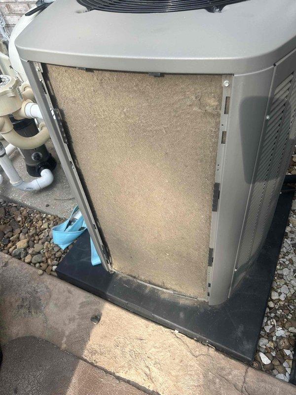Responded to no cooling complaint on 3-year-old residential air conditioning system experiencing evaporator coil freeze-up. Upon arrival, confirmed airflow present but inadequate cooling due to ice accumulation on indoor coil. Inspected outdoor condensing unit and found severely restricted airflow caused by heavily soiled air filter at condenser cabinet. Removed and documented contaminated filter showing significant dust and debris accumulation. Replaced dirty filter with new filter to restore proper airflow across condenser coils. Verified refrigerant line connections and electrical disconnect box operational. Advised homeowner to allow sufficient defrost time with fan-only operation before resuming cooling mode. System airflow restored to manufacturer specifications; unit operational upon departure.
