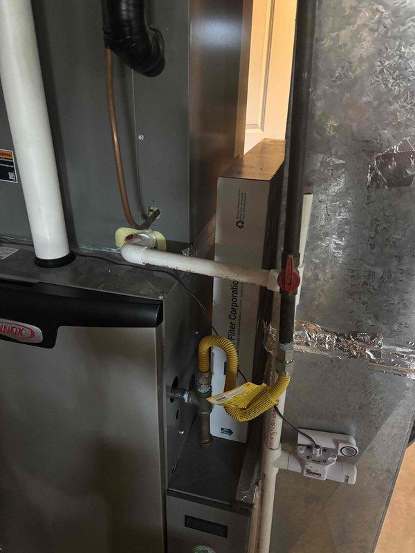 Completed follow-up visit to address outstanding HVAC installation items. Inspected and documented ductwork system including flexible metallic ducting, foil-backed vapor barrier, and fiberglass insulation in confined air handling space. Verified proper installation of furnace unit, condensate drainage system with PVC piping and safety valves, condensate pump with yellow discharge line, and refrigerant lines with reflective insulation wrapping to ensure all components meet code requirements and manufacturer specifications.