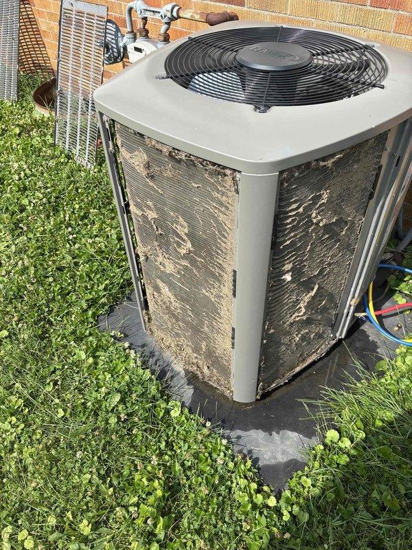 # HVAC Service Report - No Cool Condition Resolved

## Summary
Responded to no-cool complaint on 3-year-old residential AC system. Identified severely restricted airflow due to heavily contaminated outdoor condenser coil and reduced evaporator coil performance. Performed comprehensive coil cleaning on both indoor and outdoor units, restoring proper heat transfer and system cooling capacity.

## Detailed Work Performed

**Initial Assessment:**
Upon arrival, confirmed AC system was running but failing to cool effectively. Outdoor condensing unit showed excessive dirt, dust, and debris accumulation on all exterior louver panels and coil surfaces. No refrigerant ice buildup observed on either indoor or outdoor components. System age and lack of maintenance history indicated environmental contamination as primary suspect.

**Outdoor Unit Service:**
Inspected 3-year-old condensing unit positioned on concrete pad in grassy yard area. Found extensive dirt and debris buildup on condenser coil f