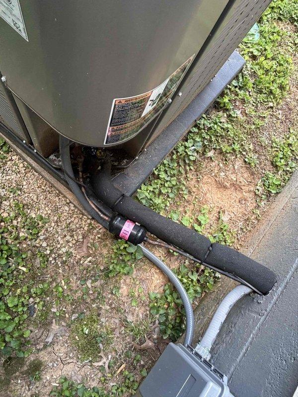 Responded to no cooling complaint on two-year-old residential HVAC system with water accumulation reported at basement unit. Upon inspection, found significant debris accumulation, dirt, and organic matter inside air handler cabinet affecting system operation. Compressor and refrigerant lines showed proper connections, but interior surfaces displayed moisture-related deterioration and contamination. Outdoor condensing unit positioned on concrete pad with proper refrigerant line connections to building. System required cleaning and drainage assessment to restore proper cooling function and address water discharge issue.