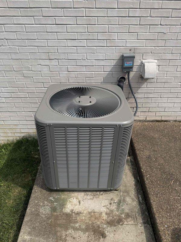 Completed installation of a 2.5-ton, 15.5 SEER air conditioning system with matching evaporator coil in an upflow configuration. The outdoor condenser unit was positioned on a concrete pad against the exterior wall with proper electrical disconnect and control wiring installed, while the indoor evaporator coil was integrated with the existing Lennox furnace system in the basement utility area with all refrigerant lines, condensate drainage, and ductwork connections properly completed and tested.