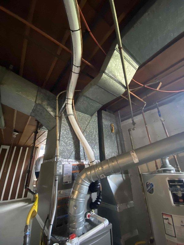 # HVAC Complete System Installation

Successfully completed full residential HVAC system installation including outdoor condensing unit and indoor air handler with associated ductwork and drainage systems. The outdoor unit was positioned on a concrete pad adjacent to the home's foundation with proper electrical conduit routing along the exterior wall. Interior installation in the basement mechanical room included mounting the air handler unit, connecting flexible metallic ductwork to existing rectangular trunk lines, and installing PVC condensate drain lines with appropriate shut-off valves. All equipment was properly secured, labeled per code requirements, and tested for operational functionality upon completion.