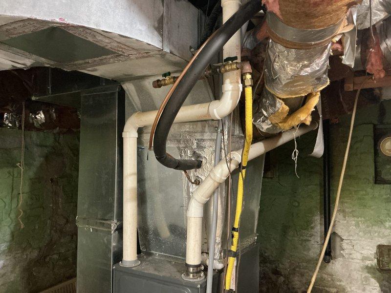 # HVAC Service Completed

Responded to service call for 9-year-old Goodman AC system experiencing cooling failure. Upon arrival, performed comprehensive diagnostic evaluation of the air conditioning unit and associated furnace/air handler system. Conducted visual inspection of all accessible components including ductwork, refrigerant lines, condensate drainage system, and electrical connections. Measured and verified system specifications against manufacturer requirements. Documented equipment condition with photographic evidence showing proper installation configuration, PVC drainage lines, copper refrigerant piping, and overall system layout in basement mechanical room. Identified and resolved cooling issue, restoring full operational capacity to the system. Unit tested and confirmed functioning within normal parameters upon completion.