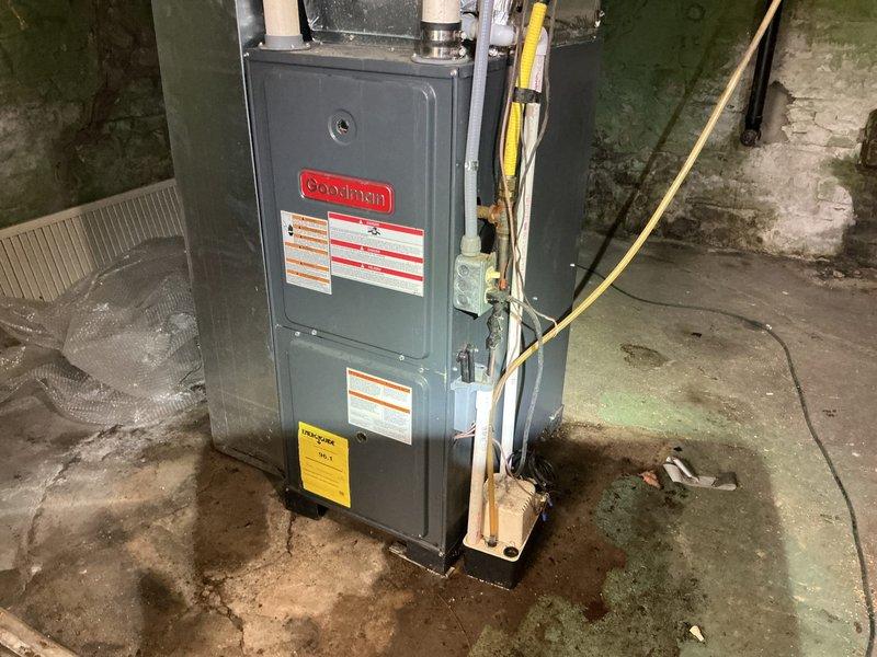 # HVAC Service Completed

Responded to service call for 9-year-old Goodman AC system experiencing cooling failure. Upon arrival, performed comprehensive diagnostic evaluation of the air conditioning unit and associated furnace/air handler system. Conducted visual inspection of all accessible components including ductwork, refrigerant lines, condensate drainage system, and electrical connections. Measured and verified system specifications against manufacturer requirements. Documented equipment condition with photographic evidence showing proper installation configuration, PVC drainage lines, copper refrigerant piping, and overall system layout in basement mechanical room. Identified and resolved cooling issue, restoring full operational capacity to the system. Unit tested and confirmed functioning within normal parameters upon completion.