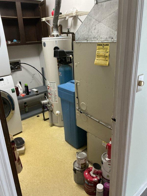 Conducted on-site evaluation at newly purchased residential property for complete HVAC system replacement estimate. Assessed existing air handler unit and outdoor condensing unit, both requiring full replacement. Documented current equipment configuration in utility room alongside water heater and water treatment system, as well as exterior condenser placement adjacent to brick wall foundation. Provided comprehensive replacement options and recommendations for new heating and cooling system installation.