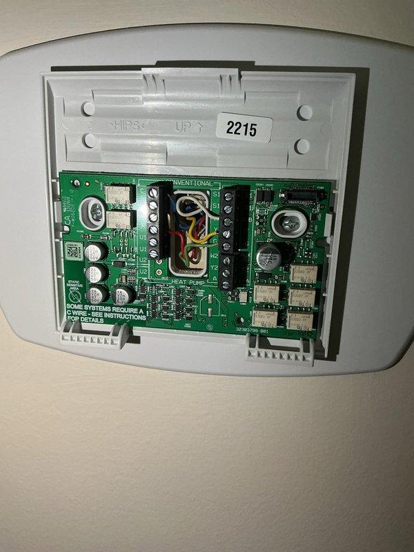 Conducted comprehensive assessment of existing HVAC system for replacement estimate. Documented current equipment configuration including wall-mounted control board with visible circuit components, terminal connections, and wiring layout. Photographed mechanical room setup featuring existing heating unit on wooden platform, associated electrical panels, copper refrigerant lines, gas supply connections, and air filtration components to provide detailed scope for Green A+ rated replacement system proposal.