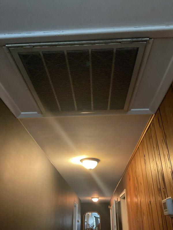 Conducted comprehensive replacement estimate for residential central air conditioning system with failed compressor. Evaluated existing outdoor condenser unit positioned on concrete pad with electrical connections and assessed interior air return system including ceiling-mounted filter grille. Documented equipment condition, measured installation areas, reviewed ductwork accessibility, and provided complete replacement options for aging HVAC system that ceased operation due to locked compressor.