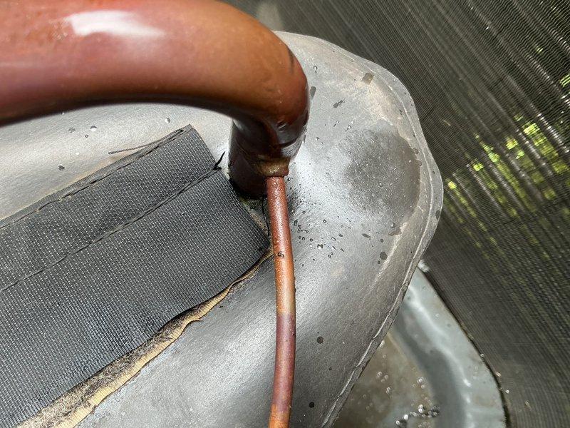 Performed follow-up leak search on HVAC system as previously identified. Conducted thorough inspection of evaporator coil assembly, refrigerant lines, and condensate pan area. Documented copper refrigerant piping connections and evaporator coil housing with photographic evidence showing potential leak locations at line set connections and coil interface points for repair authorization.