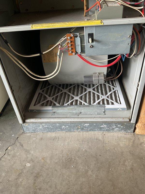 Completed comprehensive replacement estimate for 20+ year old HVAC system including both air conditioning condenser unit and furnace. Evaluated existing operational equipment, documented current interior furnace components including electrical connections, blower assembly, and air filtration system, as well as exterior condensing unit mounted on concrete pad with electrical disconnect and refrigerant line connections. Provided homeowner with complete system replacement options and efficiency upgrade recommendations for both heating and cooling equipment.