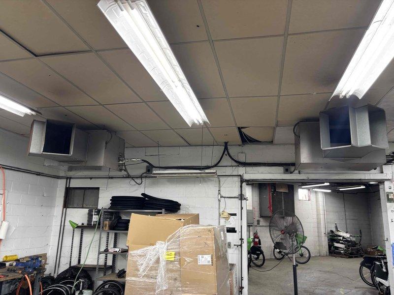 Responded to commercial single-story facility for no cooling complaint on 10+ year old rooftop unit. Upon arrival, accessed mechanical room and rooftop equipment to diagnose system failure. Found air handler in mechanical room non-operational with no airflow to conditioned space. Filter had not been serviced in 5-6 years, resulting in severely restricted airflow and system shutdown. Inspected rooftop condensing unit and associated ductwork, noting weather exposure and age-related wear on exterior components. Performed diagnostic testing on electrical components, refrigerant system, and airflow pathways. Documented equipment condition with photographic evidence showing mechanical room layout with ceiling-mounted ductwork and rooftop unit configuration. Secondary split system in office area confirmed operational, isolating issue to primary rooftop package unit serving main space.