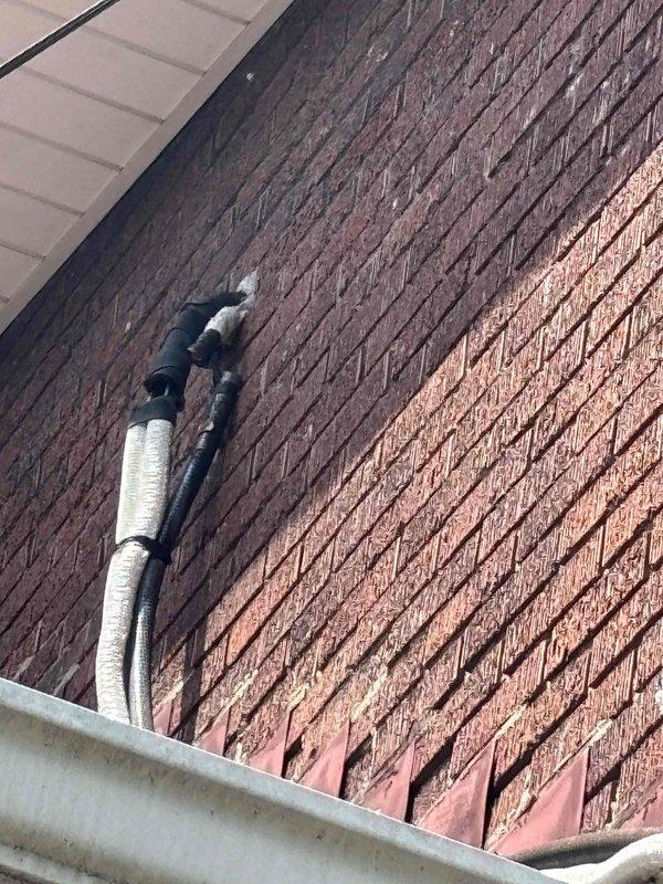 Responded to service call for mini split unit leaking water from indoor head unit onto exterior wall and roof area. Performed diagnostic assessment and attempted to clear condensate drain line from both interior and exterior access points; drain line found to be free of obstructions. Upon further inspection, determined indoor air handler is pitched incorrectly, tilting forward toward the drain connection, causing water to overflow from the unit rather than draining properly through the condensate line. Follow-up installation appointment scheduled for repositioning and leveling of the mini split head unit and correcting the condensate drain line configuration to resolve drainage issue.