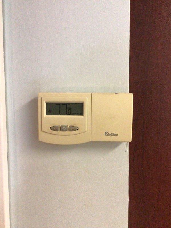Responded to no-cool service call on single-story residential property where system had frozen evaporator coil. Upon arrival, found air handler in interior closet with ice buildup that had been previously identified by handyman, unit was already shut down per recommendation to allow defrosting. Inspected Robertshaw thermostat showing 77.2°F reading, verified system was off and assessed HVAC equipment located in utility closet alongside water heater. Documented existing conditions with photos showing air handler unit with visible manufacturer labels and connected ductwork, confirmed active water leakage from melting ice with no structural damage reported at time of service.