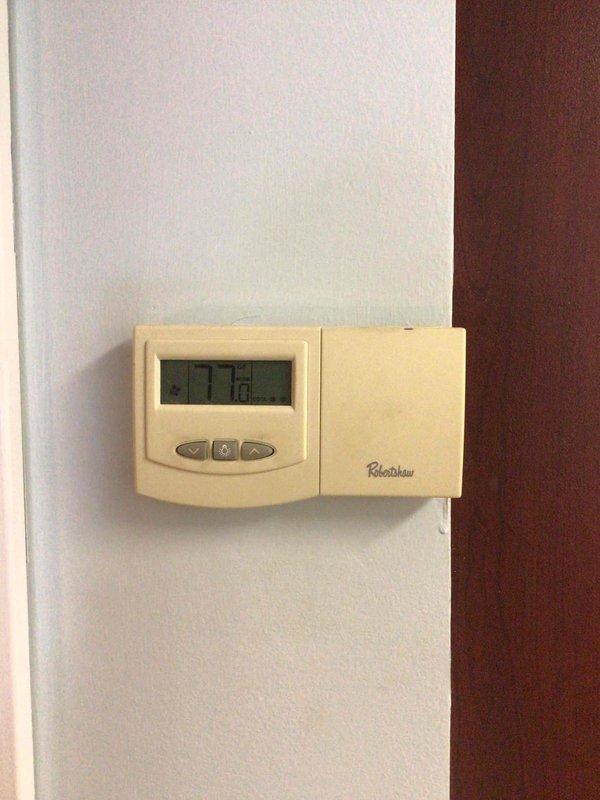 Conducted comprehensive assessment of existing HVAC system for complete replacement estimate. Inspected current Robertshaw digital thermostat displaying 77.8°F and evaluated ceiling-mounted supply/return vent system with standard white metal grille in drop ceiling configuration. Documented existing equipment conditions through detailed photography to support Green-rated A+ replacement proposal specifications. System evaluation completed to provide customer with accurate equipment replacement recommendations and energy-efficient upgrade options.