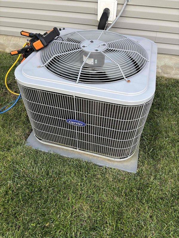 Responded to service call for air conditioning system that had shut down due to water accumulation in drain pan. Customer had cleared condensate drain line prior to arrival and unit was operational upon inspection. Performed thorough system evaluation including inspection of indoor air handler, drain pan, condensate drainage system, and outdoor Carrier condenser unit. Verified proper system operation, confirmed drain pan was empty and draining correctly, and assessed refrigerant lines for excessive condensation which may indicate insulation issues or airflow concerns. System tested and found to be functioning within normal parameters following customer's drain line maintenance.