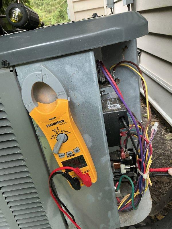 Responded to no cooling complaint with indoor temperature at 85°F on 3-year-old air conditioning system. Performed electrical diagnostics at outdoor condensing unit using clamp meter to measure amperage and verify proper power supply to compressor and condenser fan motor. Accessed electrical compartment, tested voltage at contactor and capacitor terminals, and verified all wire connections were secure. System found operating with correct electrical values; diagnosed and resolved cooling deficiency, restoring proper operation and airflow throughout residence.