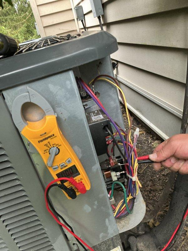 Responded to no cooling complaint with indoor temperature at 85°F on 3-year-old air conditioning system. Performed electrical diagnostics at outdoor condensing unit using clamp meter to measure amperage and verify proper power supply to compressor and condenser fan motor. Accessed electrical compartment, tested voltage at contactor and capacitor terminals, and verified all wire connections were secure. System found operating with correct electrical values; diagnosed and resolved cooling deficiency, restoring proper operation and airflow throughout residence.