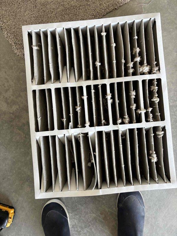 Completed first-year planned maintenance visit on HVAC system. Upon arrival, filter size was not documented in system records, so measurements were collected for future service reference. Removed and inspected air filter, which showed heavy accumulation of dust, dirt, and debris throughout all pleated sections despite the unit being only one year old. Performed diagnostic testing using refrigeration gauges, observing significant condensation on refrigerant lines indicating system was operating and cooling properly. Documented filter condition and equipment measurements with photos for service records. Filter replacement recommended due to excessive contamination that could restrict airflow and reduce system efficiency.