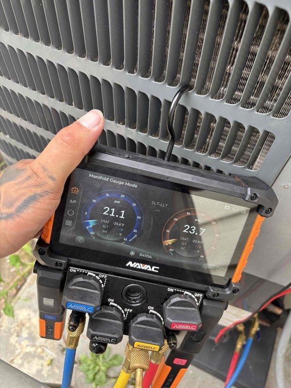 Responded to no-cooling complaint on 6-year-old residential air conditioning system with indoor temperature exceeding 90°F. Upon arrival, performed diagnostic evaluation using digital manifold gauges, which revealed critically low refrigerant pressures (21.1 PSI suction, 23.7 PSI discharge), indicating significant refrigerant loss in the system. Conducted thorough inspection of outdoor condensing unit and identified leak source. Repaired refrigerant leak, evacuated system to remove moisture and contaminants, and recharged unit to manufacturer specifications. Verified proper system operation with thermostat set to cooling mode at 80°F setpoint, confirming adequate airflow and temperature differential. System restored to full cooling capacity for elderly occupants, one with respiratory condition requiring climate-controlled environment.