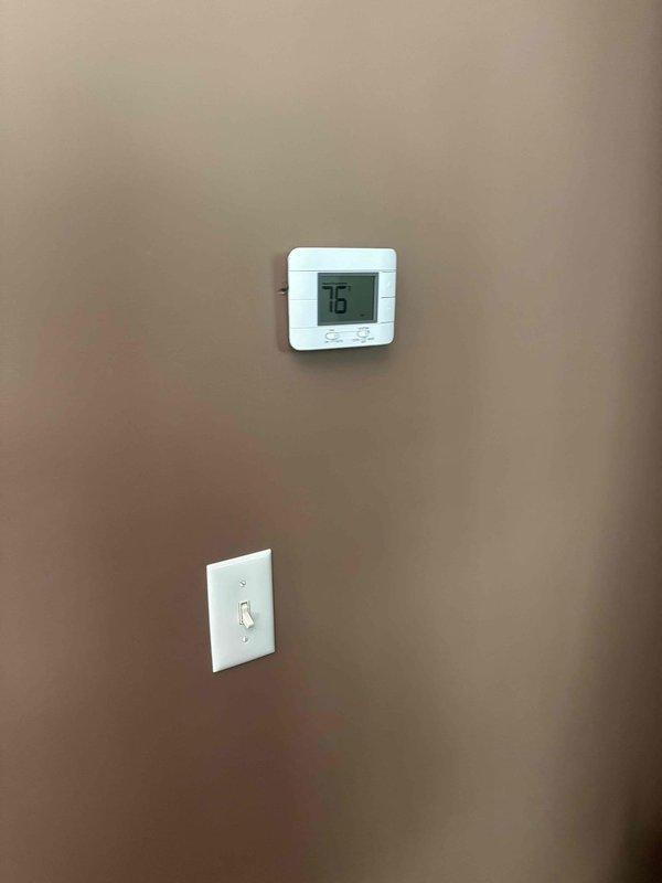 Conducted comprehensive replacement estimate for aging HVAC system experiencing intermittent operational issues. Evaluated existing outdoor condensing unit with refrigerant line set running along exterior brick wall to interior disconnect box, and assessed indoor climate control system including digital thermostat currently set at 76 degrees. Documented equipment configuration, electrical connections, refrigerant line routing, and overall system layout to provide homeowner with complete replacement options and recommendations for new high-efficiency heating and cooling equipment.