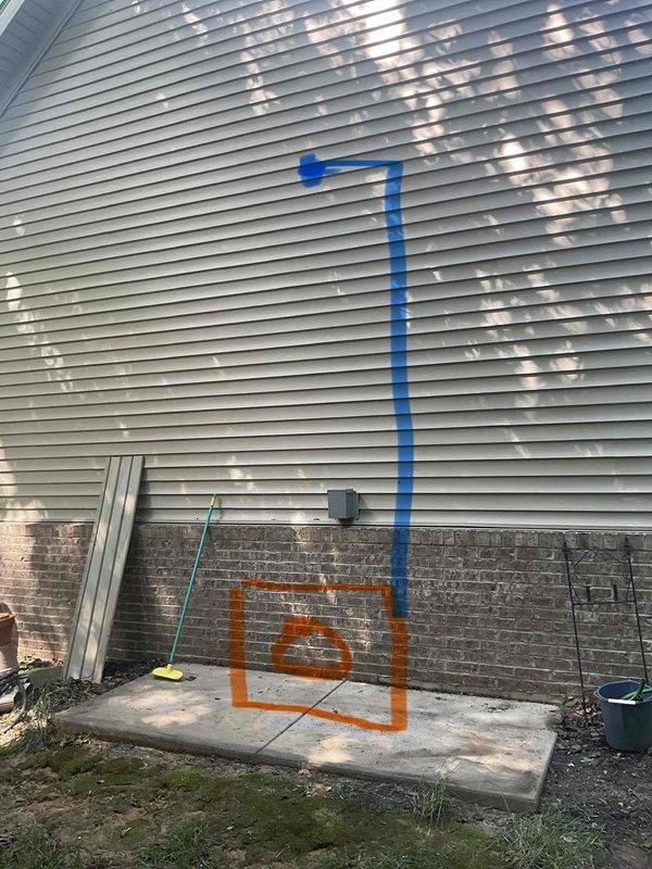 Conducted site evaluation for new 1.5 ton split system installation at owner-occupied residence with no existing HVAC equipment. Assessed exterior installation location with concrete pad and utility access point marked for outdoor condensing unit placement. Evaluated interior space including large hobby room area to determine optimal air handler positioning and ductwork routing requirements for complete system installation.
