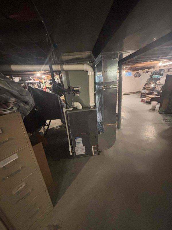Conducted comprehensive HVAC replacement estimate for non-functioning residential heating and cooling system located in basement mechanical room. Assessed existing greenish-gray furnace/air handler unit with associated ductwork and determined replacement requirements. Documented current equipment configuration including filtration system utilizing 16x25x1 Filtrete filter showing significant dust accumulation and debris buildup, indicating maintenance concerns with existing system.