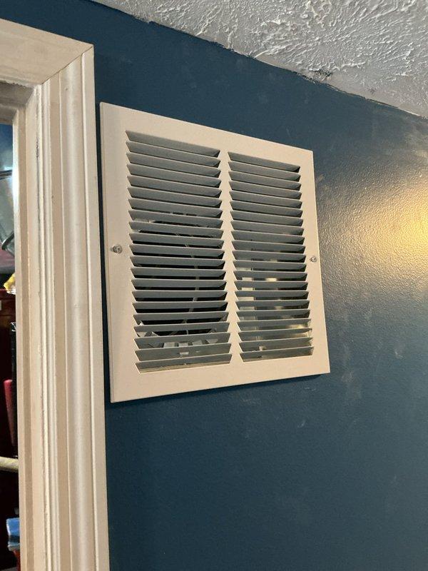 Completed warranty follow-up service to address air return vent installation issues. Sealed and taped the top of the return air ductwork at the wall penetration point to prevent air leakage and improve system efficiency. Applied proper sealing methods to the metal ductwork connections where they interface with the interior wall structure, ensuring adequate air sealing at the return air grille location.