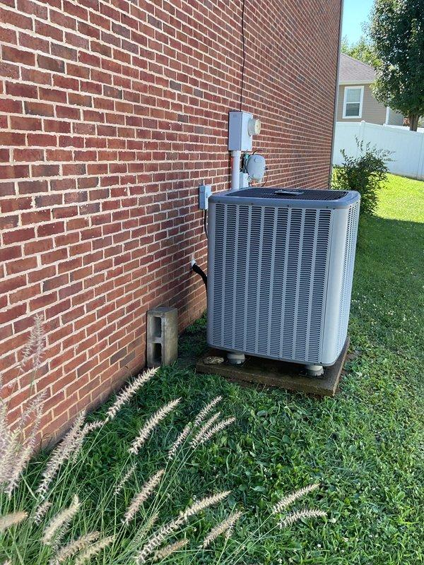 Completed Platinum Level maintenance on a single Goodman HVAC system (Model: ASPT603NHLB) serving the residence. Performed comprehensive inspection of the outdoor condensing unit positioned on concrete pad against exterior brick wall, verifying proper clearances and operational parameters. Replaced 20x20x1 air filter as part of routine maintenance protocol. Inspected condensate drain line routing along building exterior, confirming proper drainage function. Evaluated electrical connections, voltage specifications (208-230V), and circuit breaker compatibility per manufacturer specifications. Documented equipment condition through photographic records showing unit exterior, manufacturer data plate, and installation location. System operational and running within normal parameters upon completion of maintenance service.