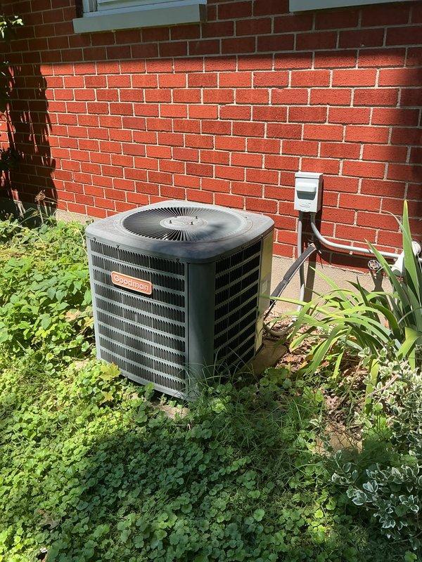 Responded to service call for outdoor condensing unit causing lights to dim and flicker throughout residence when system cycles on, accompanied by abnormal low humming noise. Upon inspection, identified hard start condition indicating compressor electrical draw issue affecting household electrical system. Evaluated condenser unit exterior condition, examined fin coil assembly for obstructions or damage, and assessed electrical disconnect and supply connections. Documented unit configuration and current operating symptoms with photographic evidence showing standard residential split system installation with adequate clearances. Recommended further electrical diagnostics to measure compressor amperage draw, capacitor testing, and potential contactor evaluation to resolve voltage drop and flickering issue.