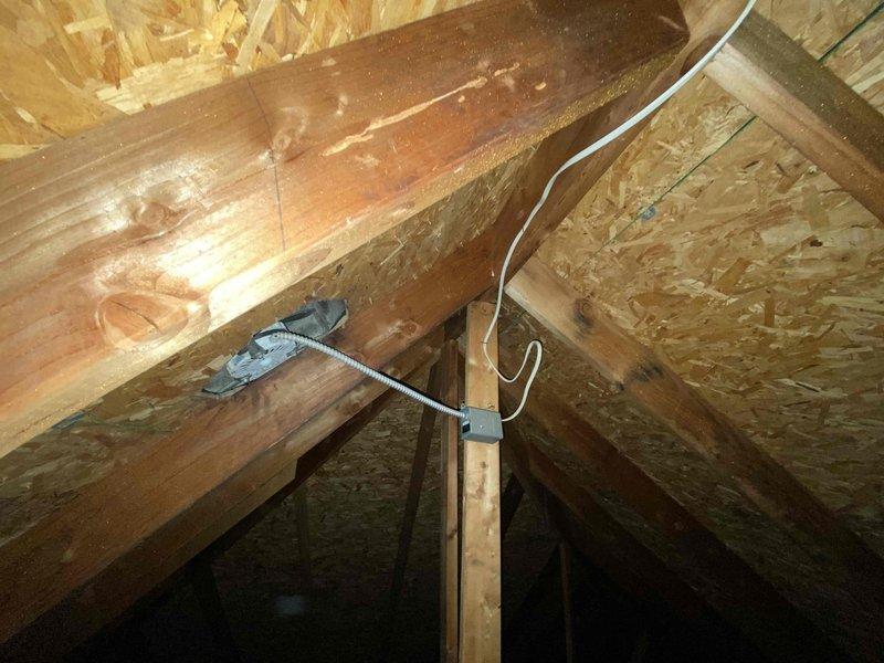 Responded to service call for attic ventilation fan producing abnormal noise that required the breaker to be shut off at night. Accessed attic space and inspected the gray exhaust fan unit mounted between roof rafters with flexible corrugated duct work. Evaluated fan motor assembly, housing, and electrical connections to identify source of rough operational sounds. Documented findings with photographs for insurance documentation purposes as requested.