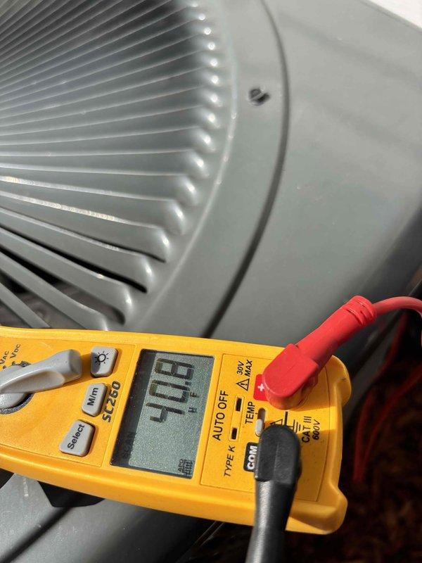 Responded to callback for recurring AC disconnect switch tripping on a 2-year-old system. Upon arrival, unit was operational as occupant had reset the disconnect. Performed comprehensive electrical diagnostics using digital multimeter to identify root cause of nuisance tripping. Tested voltage and amperage at disconnect switch and condenser unit, measuring 420V and verifying proper electrical parameters. Inspected compressor windings, contactor operation, and capacitor performance. All electrical readings within manufacturer specifications with no signs of short circuit, ground fault, or excessive amp draw that would cause disconnect to trip. Examined outdoor unit components including condenser fan motor and compressor for mechanical issues. Found no defects in equipment operation or wiring connections. System cooling properly with normal temperature differential. Documented findings with diagnostic photos showing test equipment readings and unit condition for warranty records.
