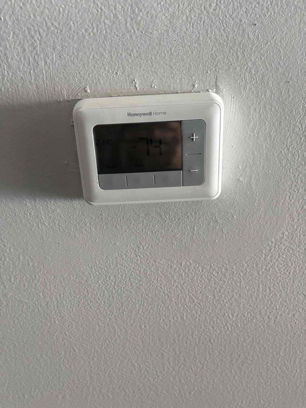 Conducted comprehensive replacement estimate for existing 25+ year old HVAC system with heat pump conversion evaluation. Assessed current operational cylindrical condenser unit with top-discharge configuration, electrical disconnect, and refrigerant line routing along exterior brick wall, as well as interior Honeywell Home thermostat. Documented existing equipment specifications, measured installation space requirements, evaluated electrical service capacity, and provided homeowner with heat pump replacement options to improve system efficiency and performance.