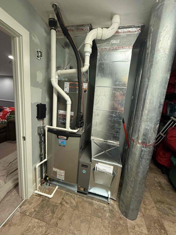 Completed full HVAC system installation including a 5-ton, 18 SEER outdoor Lennox condensing unit and upflow furnace with zoning capability. Installed indoor air handler with proper ductwork connections and sheet metal plenum in utility closet, routed condensate drain lines using white PVC piping, and ran electrical conduit from outdoor disconnect box to unit. Mounted outdoor condenser on composite pad with proper clearances from structure, installed electrical disconnect and junction boxes on exterior wall, and verified all refrigerant lines, electrical connections, and duct transitions are secure and sealed. System tested and operational with all zones functioning correctly.