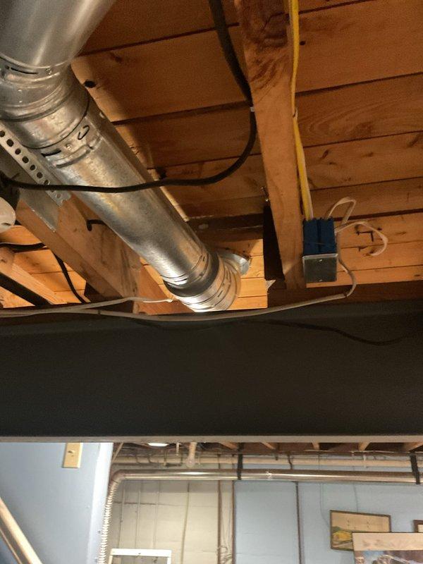 Conducted comprehensive HVAC system replacement estimate at residential property with existing operational equipment. Evaluated outdoor condensing unit positioned on gravel pad against brick exterior wall, assessed refrigerant line routing and structural mounting conditions. Inspected interior ductwork system including flexible aluminum ducting, examined basement ceiling-mounted distribution network, evaluated existing electrical connections and junction box locations to determine replacement specifications and compatibility requirements for new high-efficiency system installation.