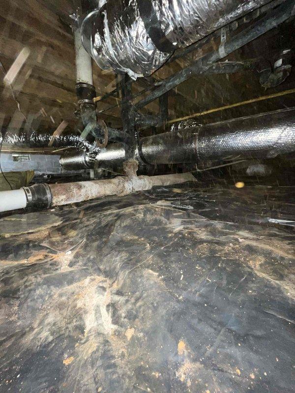 Completed comprehensive ductwork installation in crawl space and attic areas. Installed flexible metallic ductwork with proper support strapping, integrated reflective insulated piping for HVAC distribution, and ensured proper vapor barrier placement throughout the underfloor space. All ductwork was secured to structural joists per code requirements, with connections made to existing HVAC system components including white PVC drainage lines.