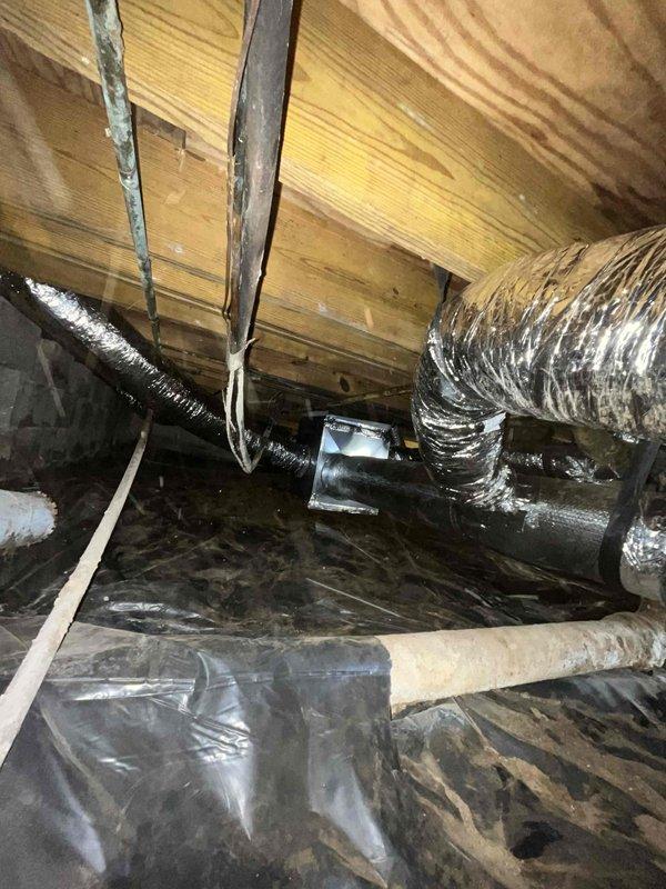 Completed comprehensive ductwork installation in crawl space and attic areas. Installed flexible metallic ductwork with proper support strapping, integrated reflective insulated piping for HVAC distribution, and ensured proper vapor barrier placement throughout the underfloor space. All ductwork was secured to structural joists per code requirements, with connections made to existing HVAC system components including white PVC drainage lines.