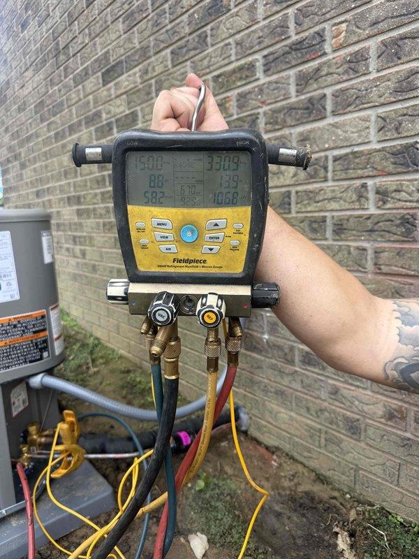 Completed installation of 4-ton, 17 SEER, 97% AFUE complete HVAC system at residential property. New outdoor condensing unit positioned on concrete pad against exterior brick wall with proper clearances maintained, electrical disconnect installed, and system commissioned with digital manifold gauges confirming proper refrigerant charge and operational parameters across all zones.