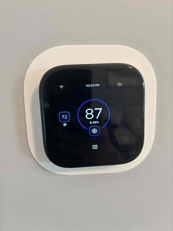 Responded to no cooling complaint on 15-year-old heat pump system. Upon arrival, performed diagnostic evaluation of outdoor unit and indoor components. Identified deteriorated electrical connections at outdoor unit with visible weathering and compromised wiring integrity on junction box. Inspected thermostat operation showing 87°F indoor temperature against 72°F setpoint with cooling mode engaged. Assessed compressor operation, refrigerant circuit, and electrical supply to condenser unit. Documented equipment condition with photos showing extensive weathering on outdoor unit mounting surface and electrical connection points requiring attention. System evaluated for age-related component degradation and cooling capacity performance.