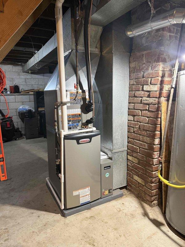 Completed full HVAC system installation in basement location, including 2-ton 15 SEER 97% AFUE heating and cooling equipment. Installed new furnace unit positioned on concrete floor adjacent to existing brick chimney structure with proper clearances maintained. Connected sheet metal supply ductwork from furnace plenum to existing distribution system through ceiling joists. Routed condensate drainage using PVC piping with proper pitch and termination. Verified all electrical connections, gas line connections, and combustion air requirements meet manufacturer specifications and local code. System startup performed with operational testing of heating and cooling modes. All safety controls and limit switches tested and functioning properly. Customer upgraded from existing system through financing program.