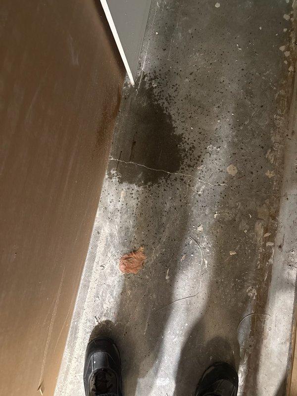 Responded to callback regarding water damage from condensate line issue. Documented extensive ceiling damage including compromised drywall with exposed cavity, visible electrical wiring, and water staining radiating from failure point. Photographed concrete floor showing black mold growth and moisture contamination beneath affected area. Customer reported damage to three light fixtures and surrounding drywall from condensate buildup that occurred during initial installation visit.