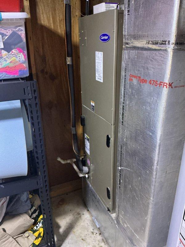 Responded to water leak complaint at Carrier HVAC system. Upon inspection, identified moisture issue originating from evaporator coil and filter area of vertical air handler unit. Examined refrigerant lines, condensate drainage system, and coil housing for source of leak. Cleared condensate drain line obstruction, verified proper drainage flow, and confirmed system operation. Tested unit through full cooling cycle to ensure leak was resolved and all components functioning properly.