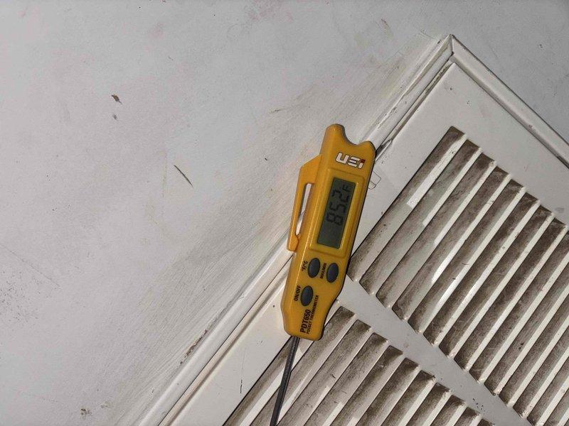Responded to no cooling complaint on 6-year-old residential HVAC system experiencing reduced airflow and inability to maintain temperature setpoint. Performed diagnostic evaluation measuring supply air temperature at 57.4°F at register and return air conditions. System was found struggling to keep up with cooling demand, resulting in owner shutting unit down prior to arrival. Completed airflow assessment and temperature differential measurements to identify root cause of inadequate cooling performance.
