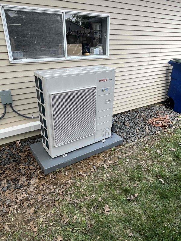Completed installation of 24,000 BTU ductless mini-split system with single indoor head unit and outdoor Lennox condenser. Indoor evaporator mounted in interior mechanical room with refrigerant lines and electrical connections concealed through wall penetration; outdoor condensing unit positioned on composite pad against building exterior with proper clearances maintained. System tested and operational upon completion.