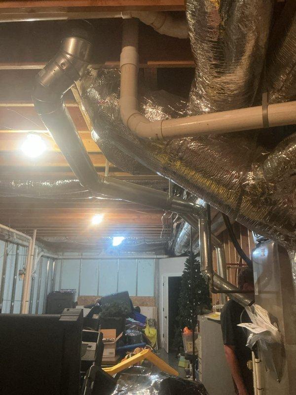 Responded to no cooling call on 15-year-old heat pump and air handler system with repeated breaker tripping issues. Upon arrival, indoor temperature was 84 degrees with no airflow from vents. Performed diagnostic inspection of Carrier furnace/air handler unit and associated electrical components in basement mechanical room. Identified electrical fault causing continuous circuit breaker trips, preventing system operation. Inspected ductwork, condensate drainage, and overall HVAC infrastructure for additional issues. Documented equipment condition and basement utility area configuration with photographic evidence showing air handler placement, ductwork routing, and mechanical room layout. System required electrical repair to restore cooling function and prevent further breaker trips.
