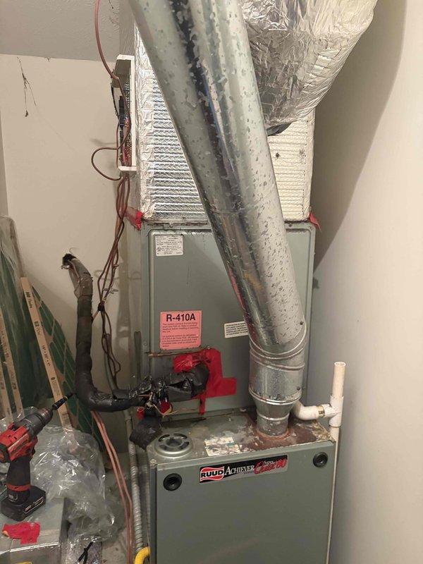 # Summary

Provided second opinion on 17-year-old Ruud system with no cooling and excessive condensation in drip pan. Previous company diagnosed thermal expansion valve failure, which was confirmed during inspection along with significant condensation buildup on refrigerant lines indicating restricted refrigerant flow.

# Work Performed

Arrived on site and performed comprehensive diagnostic evaluation of non-cooling HVAC system. Verified thermostat operation showing room temperature at 77°F with set point at 74°F in cooling mode. System was energized but failing to achieve desired temperature.

Inspected evaporator coil assembly and refrigerant lines in utility closet installation. Observed heavy condensation accumulation on metallic ductwork and refrigerant piping, indicating potential restriction in refrigerant circuit. Examined R-410A system components including furnace unit, electrical panel, and associated refrigerant lines with red valve handles.

Confirmed previous diagnosis of