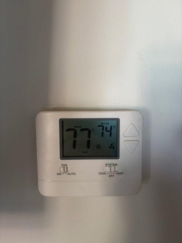 # Summary

Provided second opinion on 17-year-old Ruud system with no cooling and excessive condensation in drip pan. Previous company diagnosed thermal expansion valve failure, which was confirmed during inspection along with significant condensation buildup on refrigerant lines indicating restricted refrigerant flow.

# Work Performed

Arrived on site and performed comprehensive diagnostic evaluation of non-cooling HVAC system. Verified thermostat operation showing room temperature at 77°F with set point at 74°F in cooling mode. System was energized but failing to achieve desired temperature.

Inspected evaporator coil assembly and refrigerant lines in utility closet installation. Observed heavy condensation accumulation on metallic ductwork and refrigerant piping, indicating potential restriction in refrigerant circuit. Examined R-410A system components including furnace unit, electrical panel, and associated refrigerant lines with red valve handles.

Confirmed previous diagnosis of