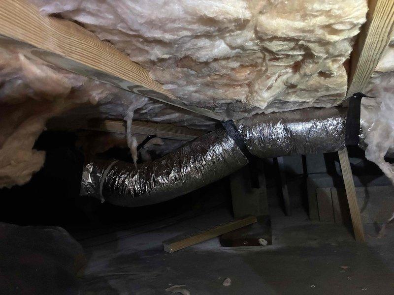 Completed diagnostic inspection on 1-year-old HVAC system with reported operational concerns. Accessed crawlspace to inspect flexible ductwork installation and support strapping. Verified floor register placement and airflow distribution to living space. Documented existing conditions of insulated supply duct routing and structural support components. System confirmed operational at time of service with repair parts ordered and ready for installation upon arrival.