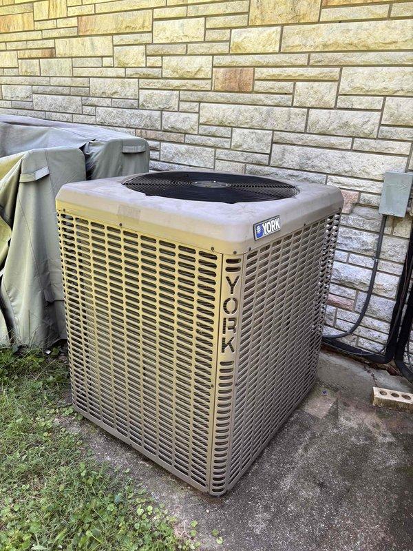 Responded to no-cooling call on approximately 10-year-old York condenser unit that was completely inoperative. Upon arrival, performed diagnostic evaluation of the non-functioning system and documented unit condition with exterior photographs showing condenser placement, electrical connections, and refrigerant line routing. Assessed electrical components including conduit runs and junction boxes mounted on building exterior. Inspected concrete pad condition and noted normal weathering consistent with system age. Completed visual inspection of second unit experiencing rapid cycling issues to determine service priorities. Documented both systems for maintenance records and provided recommendations for restoring cooling operation to primary unit.